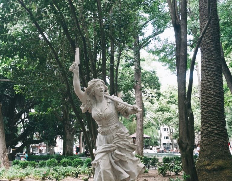 Lago do Jardim da Parada com pessoas sentadas à volta